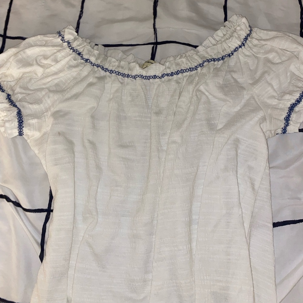 White shirt with puff shoulders and blue around neckline/sleeves